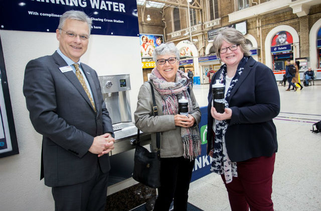 Photo of 3 people stood by a free water drinking fountain in Charing Cross station.