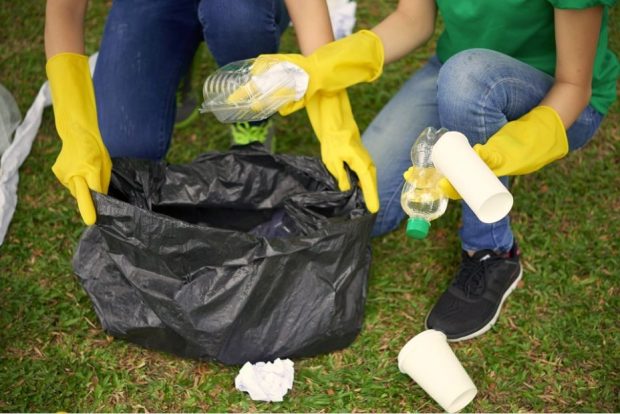 A close up image of two people collecting litter.