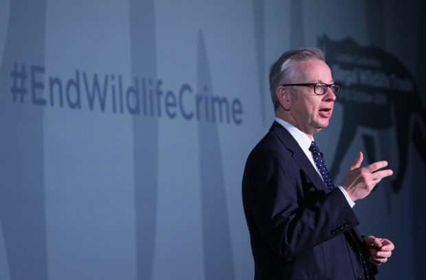 The Environment Secretary speaking at the IWT conference against a banner which says #EndWildlifeCrime
