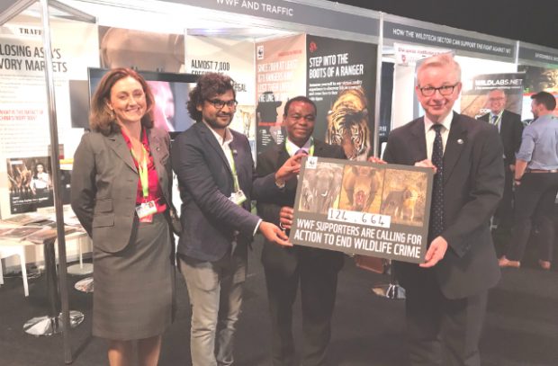 An image of Environment Secretary Michael Gove accepting a petition from the WWF, standing surrounded by three other people.