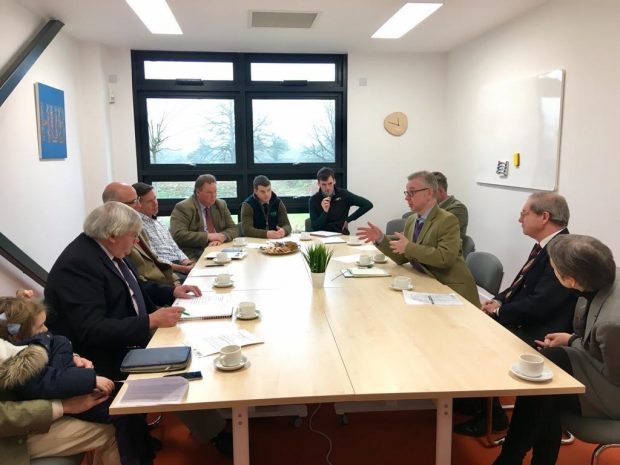 An image of the Environment Secretary speaking at a roundtable with the Royal Agricultural University and Gloucestershire Wildlife Trust, surrounded by other people.