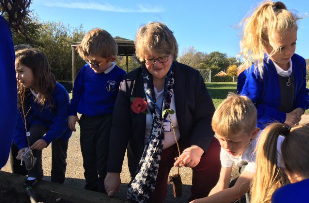 Minister Coffey kneeling next to pupils from Saxmundham Primary School