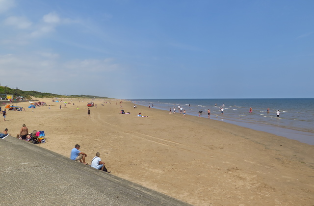 An image of people sunbathing at the beach on a sunny day.