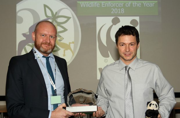 Photo of PC Dewi Evans receiving his award against a panda backdrop. 