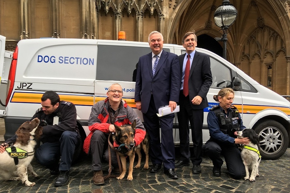 Image of PC Wardell, Sir Oliver Heald and Animal Welfare Minister standing in front of a van with dogs.