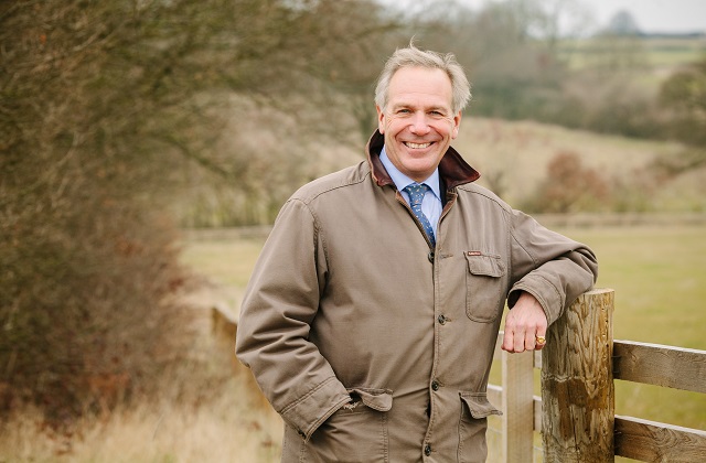 Image of Government's Tree Champion, Sir William Worsley standing by a fence in a field.