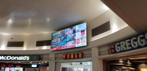 Image of a service station with anti-litter campaign advert on the screen.