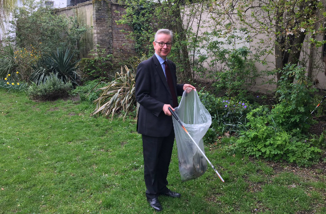 Image of Michael Gove holding a bin bag collecting rubbish.