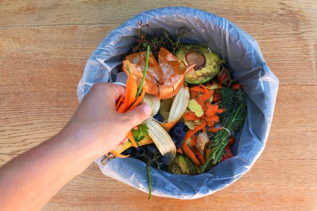 Picture of someone throwing food in the bin.