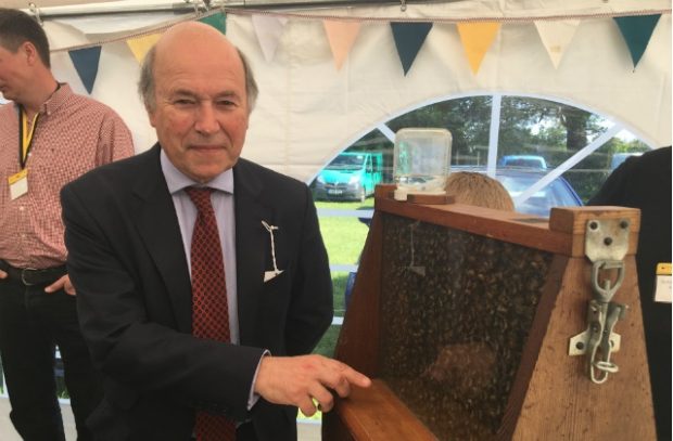 Lord Gardiner standing next to a hive of bees