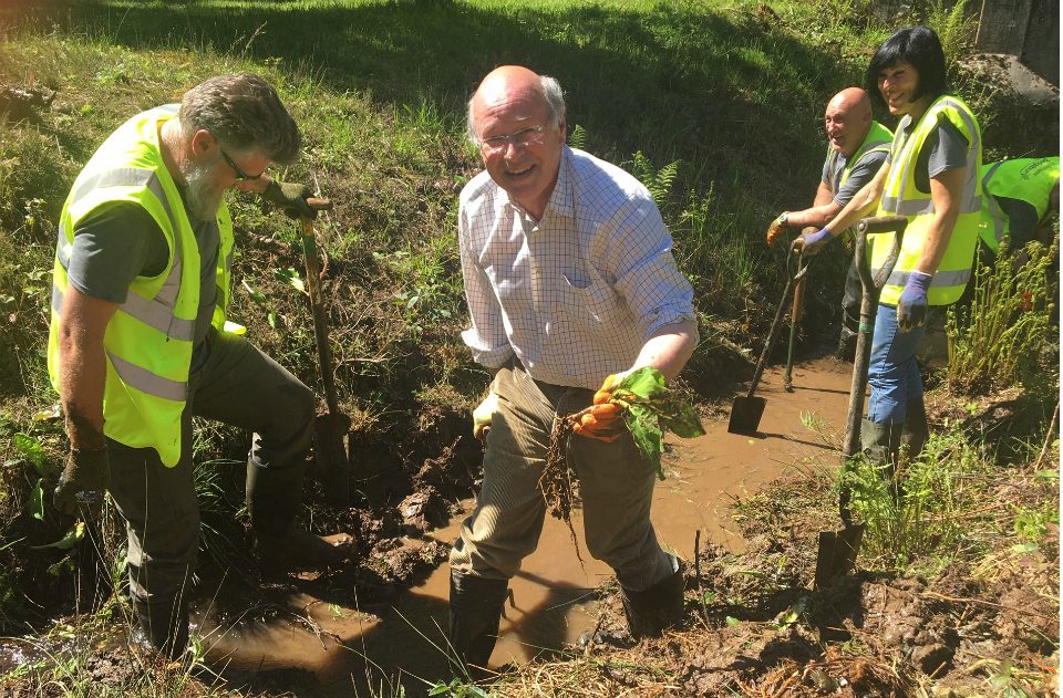 Lord Gardiner digging up skunk cabbage