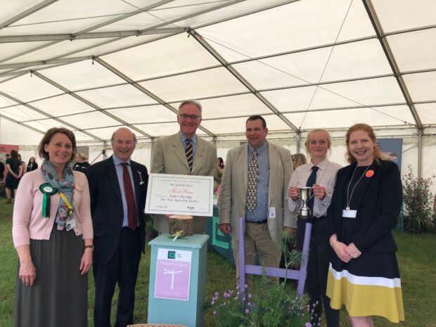 Lord Gardiner stood with members of Easton and Otley college behind a certificate