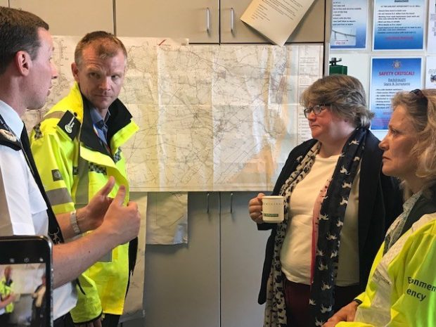 An image of Minister Coffey and Environment Agency officer's in front of a map of Lincolnshire 