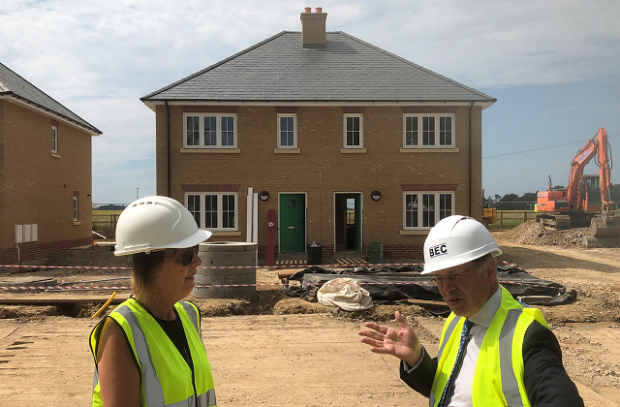 English Rural's Senior Regional Development Director Alison Thompson and Lord Gardiner stand outside a housing construction site in Throwley Kent