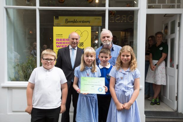 Lord Gardiner, George McGavin and pupils from the Heron Hill primary school in Kendal stand in front of the ‘Hive’ on 3 Newburgh Street. The pupils are holding their Bees’ Needs School Award certificate which recognises their efforts to help pollinating insects.