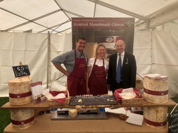 Lord Gardiner with two people at a stall selling cheese