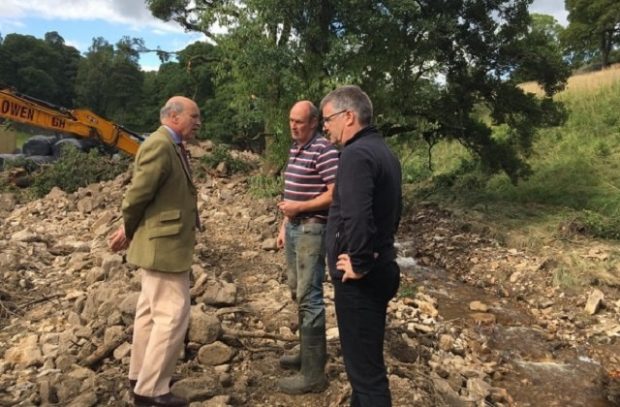 Lord Gardiner speaking with two farmers standing next to a stream in the Yorkshire Dales