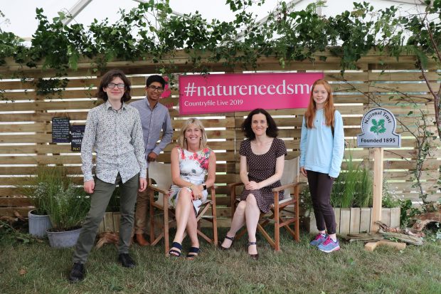 Image of Environment Secretary Theresa Villiers with Hilary McGrady, Director General of the National Trust, and three young environmentalists