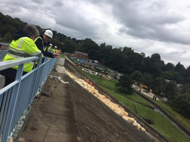 An image of Minister Coffey looking over the recovery efforts at Whaley Bridge.