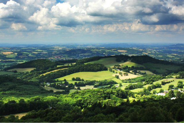 An image of the Malvern Hills landscape in the sunlight with the clouds and blue sky above