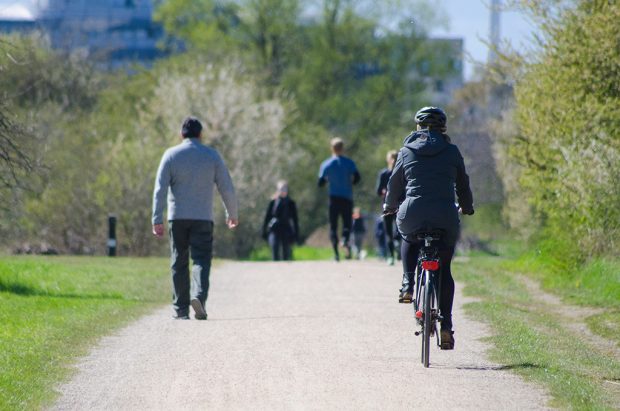 An image of two adults enjoying a cycle ride in a park 