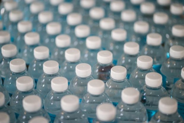 A collection of clear plastic bottles with white bottle tops.