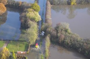 Arial shot of van driving through farmland flooded in November 2019