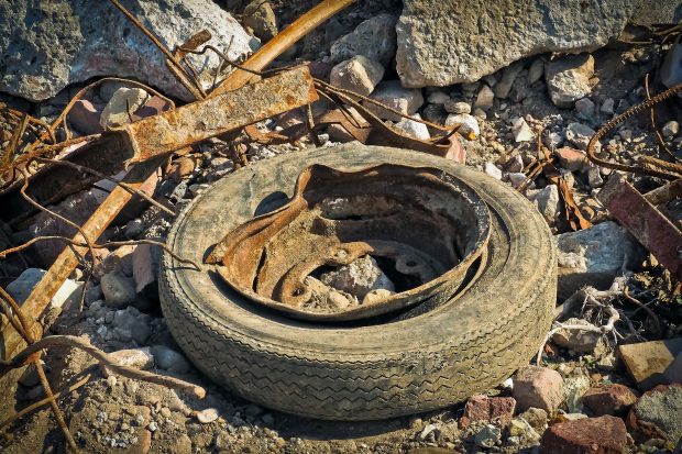 A pile of waste including rubble, scrap metal and a disused tyre