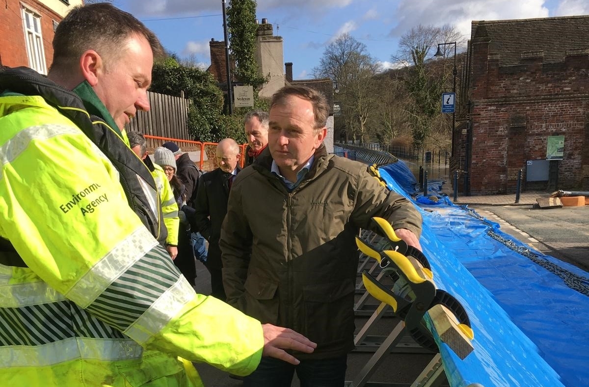 environment agency staff member and george eustice inspect flood defences