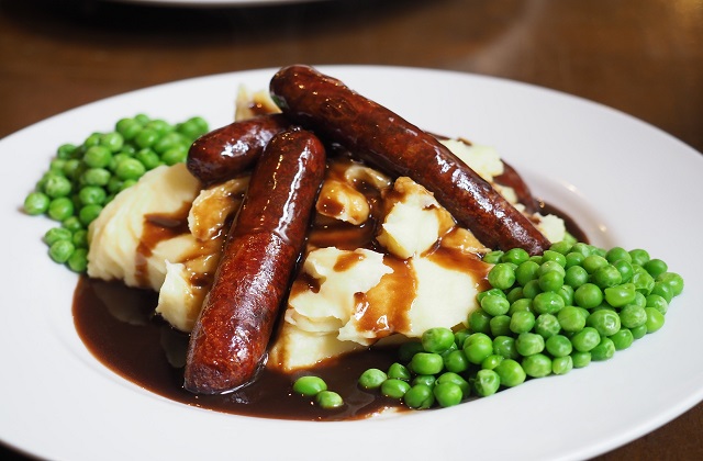 Sausages, peas and mashed potatoes with gravy on a plate