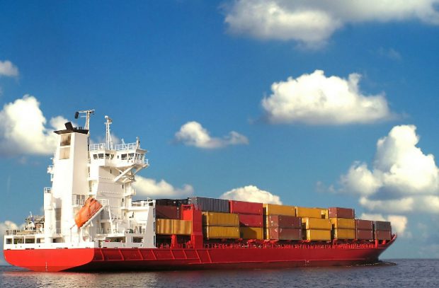 A long cargo ship at sea with stacks of containers on it