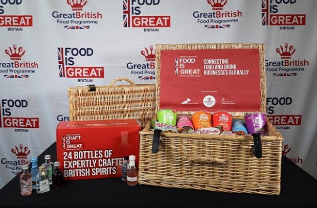 An image of two hampers containing British food and spirit samples, with the branding backdrop of the Food is GREAT campaign images