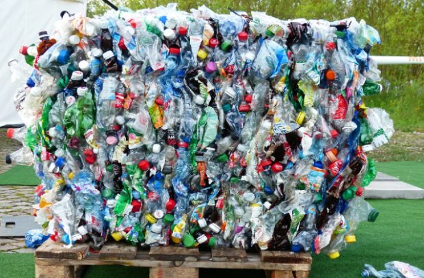 A large consignment of flattened plastic bottles, crused into a cube shape