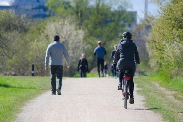 Woman cycling through a park