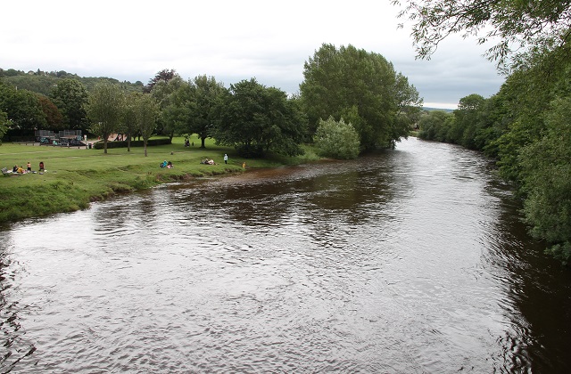 People standing on the bank of the River Wharfe near Ilkely