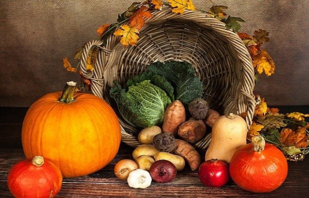 An image of various seasonal vegetables in front of a basket