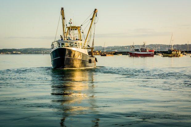 Fishing-boats-leaving-an-Engish-harbour-in-the-early-summer-morning-with-the-boats-at-rest