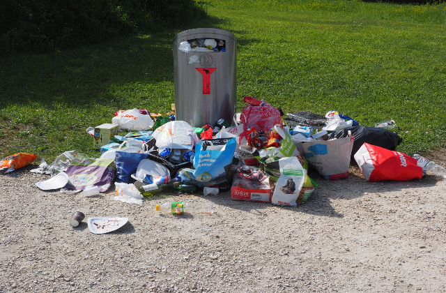 Litter strewn around an overflowing bin.