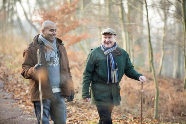 Image of two men walking in a woods. 