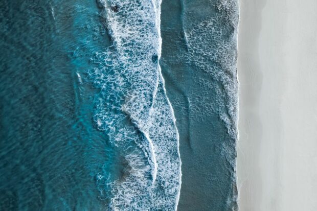 Aerial-view-of-sea-lapping-onto-beach