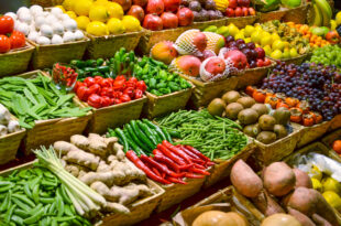 Crates of various fruits and vegetables stacked in a market